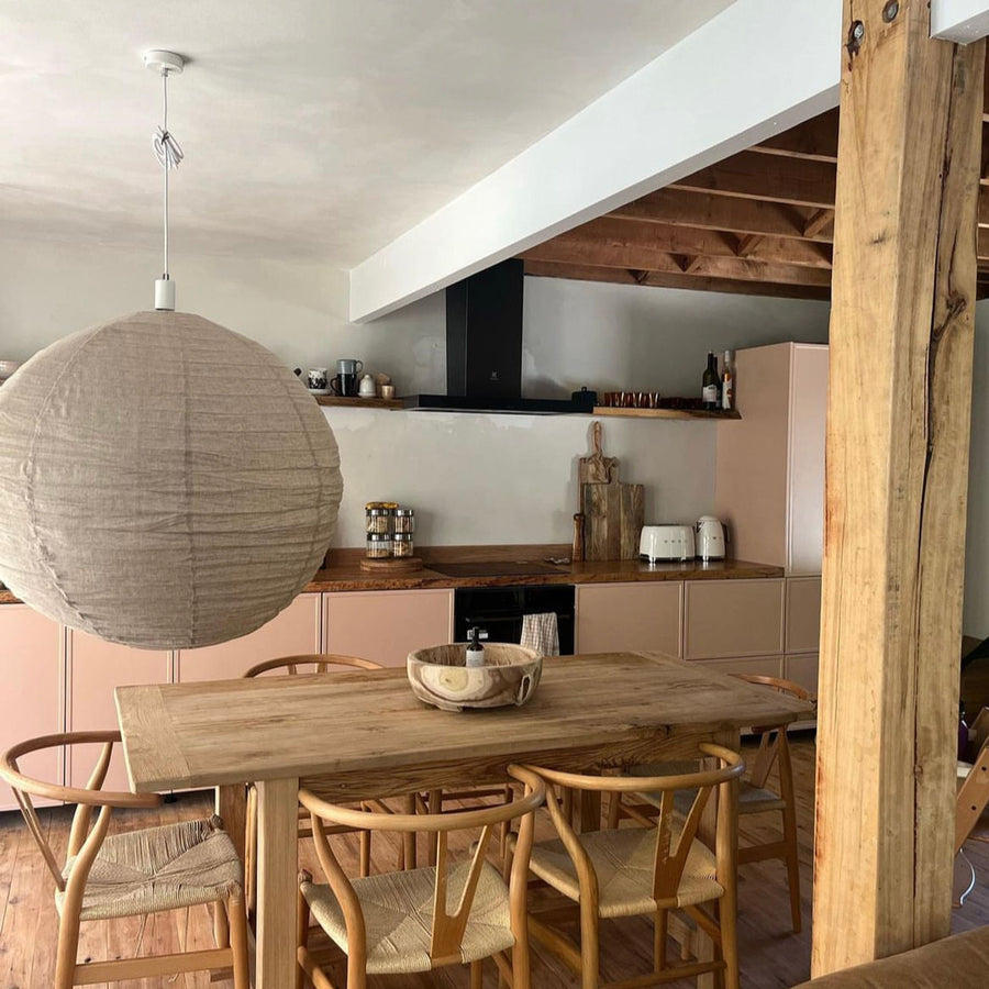 IKEA METOD kitchen with pale pink Slim Shaker doors in a custom colour, seen past a timber dining table and a paper pendant light