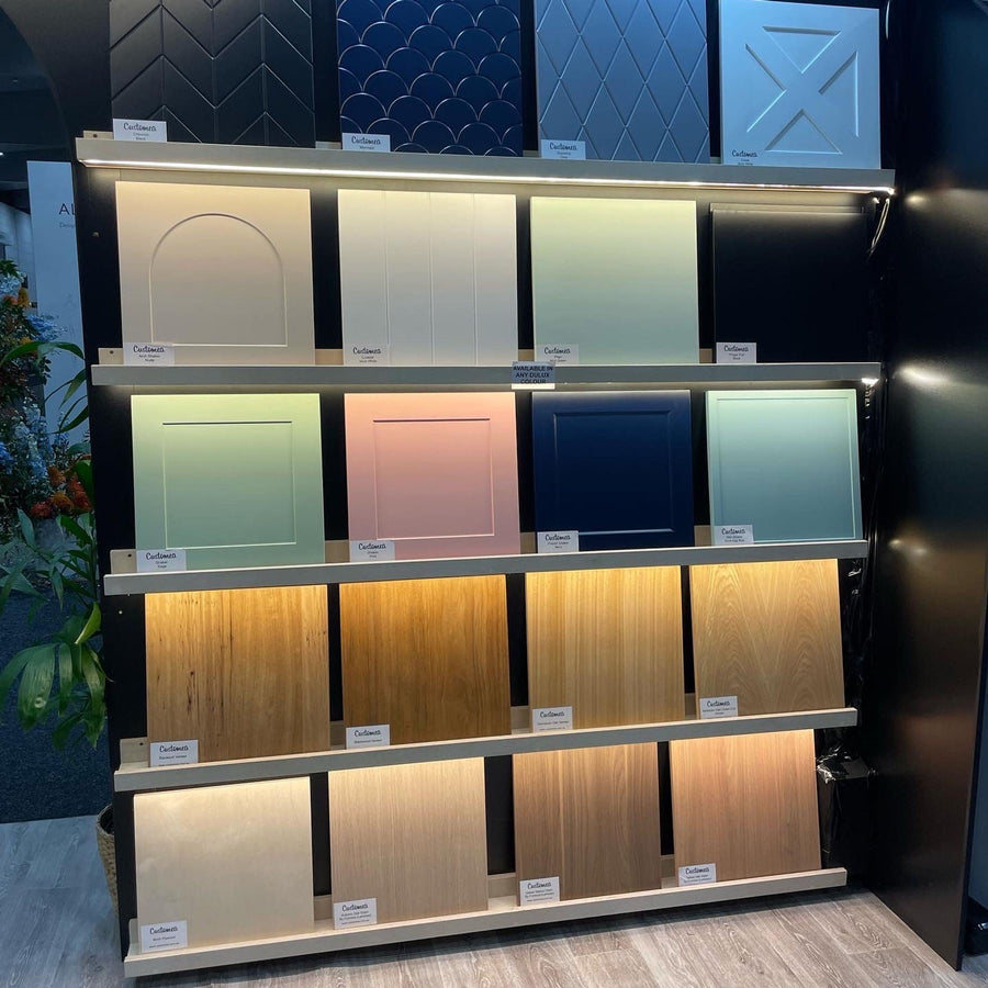 Customea sample wall with painted, profiled and woodgrain door samples on lit shelves