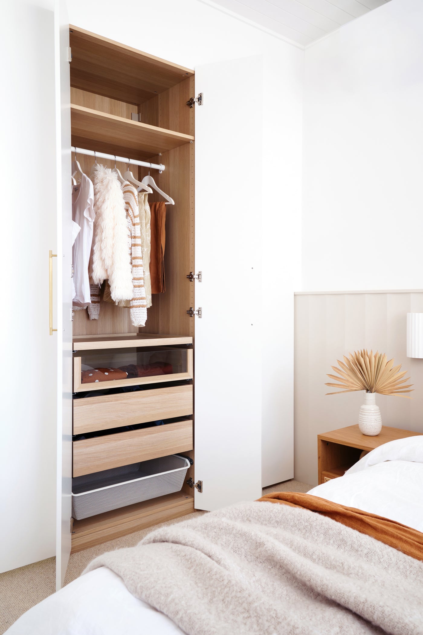 Full-height warm white wardrobe fronts with an oak display niche